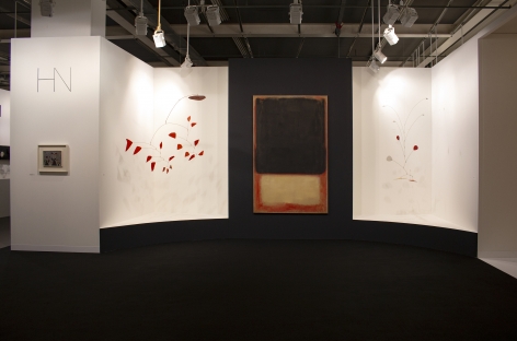 Installation view of Art Basel | Basel 2019, booth H5. ©Helly Nahmad Gallery NY. Photography by Studio MDA. This photo features the inside of the booth, A latge scale painting by Mark Rothko is in the center, two Calder mobile are suspended from the ceiling on each side. On the left side we can see a small painting by Joan Miro hung on the wall.